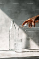 Pouring Water into a Glass with Sunlit Reflections