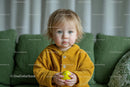 Adorable Toddler in Yellow Sweater Holding Toy