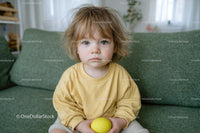 Adorable Toddler in Yellow on Green Sofa