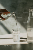 Refreshing Water Pouring into Glass in Soft Sunlight