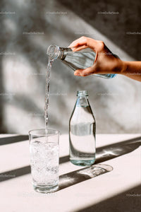Refreshing Water Pouring into a Glass on a Sunny Day