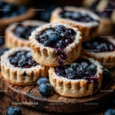 Homemade Blueberry Tarts on Rustic Wooden Board