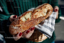 Golden Crust Baguette in Hand with Striped Cloth