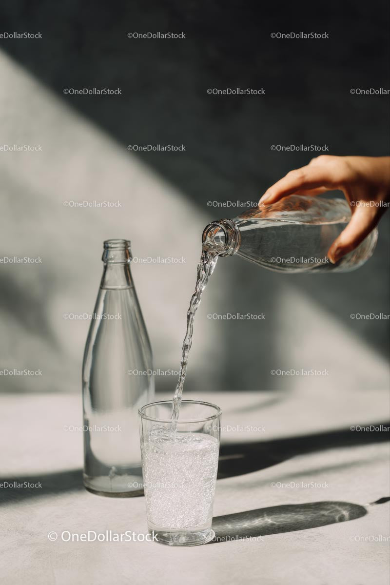 Pouring Water into a Glass with Sunlit Reflections