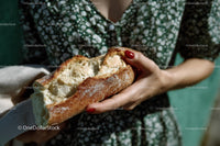 Crusty Baguette Held by Woman in Green Summer Dress