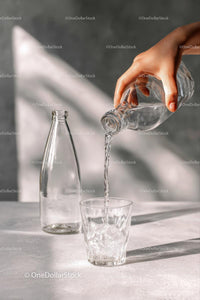 Pouring Fresh Water into a Glass on Sunny Morning