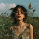 Young Woman in Floral Dress Amidst Grassy Fields