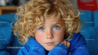 Blonde Child with Curly Hair and Blue Eyes in a Blue Hoodie