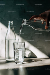 Pouring Water into Glass in Sunlit Kitchen