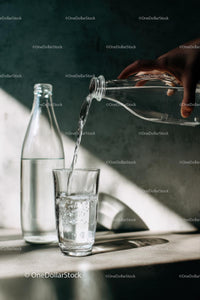 Pouring Water into a Glass with Sunlit Reflections