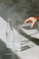 Pouring Water into a Glass in Sunlit Setting