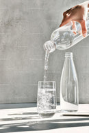 Pouring Water into a Glass with Sunlit Reflections