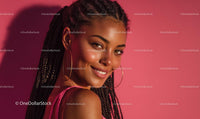 Smiling Woman with Braided Hair Against Pink Backdrop