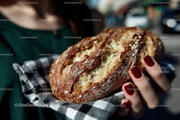 Hand Holding Freshly Baked Crusty Sourdough Bread