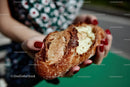 Hands Holding Artisan Bread with Melted Cheese