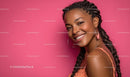 Smiling Woman with Braids and Hoop Earrings on Pink Background