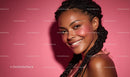 Stylish Woman with Braids Smiling Against Pink Background