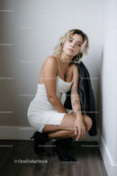 Confident Woman in White Dress with Leather Jacket
