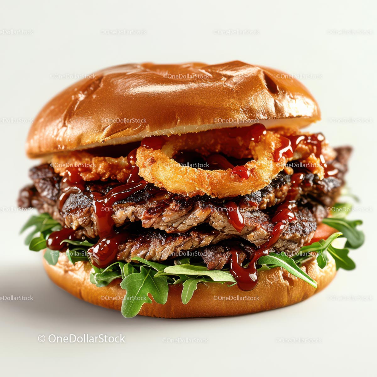 Soczysty burger wołowy z krążkami cebulowymi i rukolą
