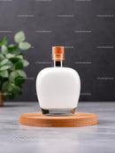Minimalist Glass Bottle on Wooden Base with Greenery