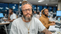 Bearded Man with Headphones in a Modern Office Environment