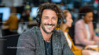 Smiling Man with Headset in Modern Office Environment