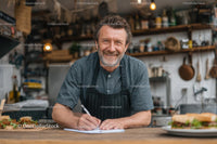 Smiling Chef in Rustic Kitchen Taking Culinary Notes