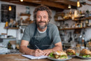 Smiling Chef Writing Menu in Rustic Cafe