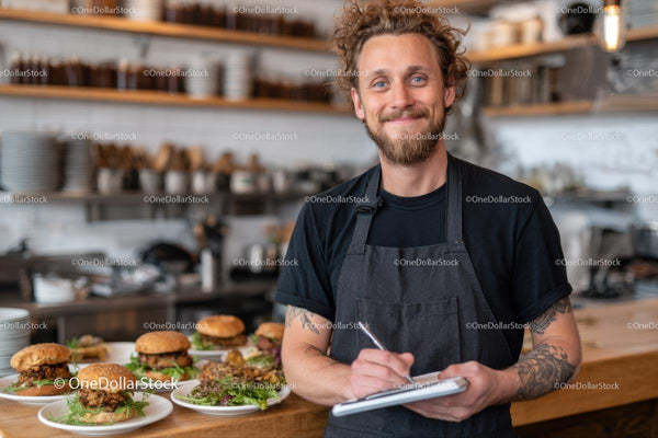 Smiling Chef Preparing Gourmet Burgers in Modern Kitchen