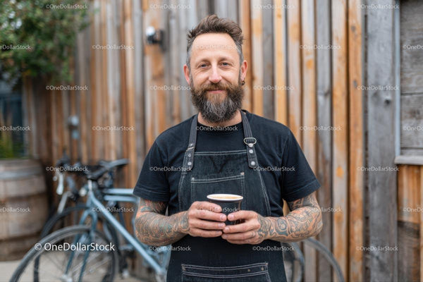 Tattooed Barista Holding Coffee in Rustic Setting