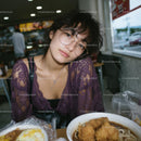 Young Woman with Purple Lace Top Dining in Urban Eatery