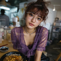 Young Woman with Purple Lace Top Dining in Urban Eatery