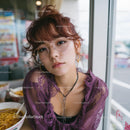Trendy Woman in Purple Lace Top at Dining Table