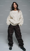Model Posing in Cozy Knit Sweater with Brown Pants