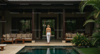 Woman Walking by Tranquil Pool in Tropical Villa
