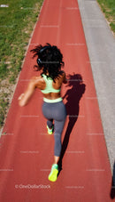 Woman Jogging on Red Running Track in Bright Sportswear