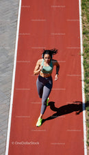 Athletic Woman Jogging on a Red Track in the Sun