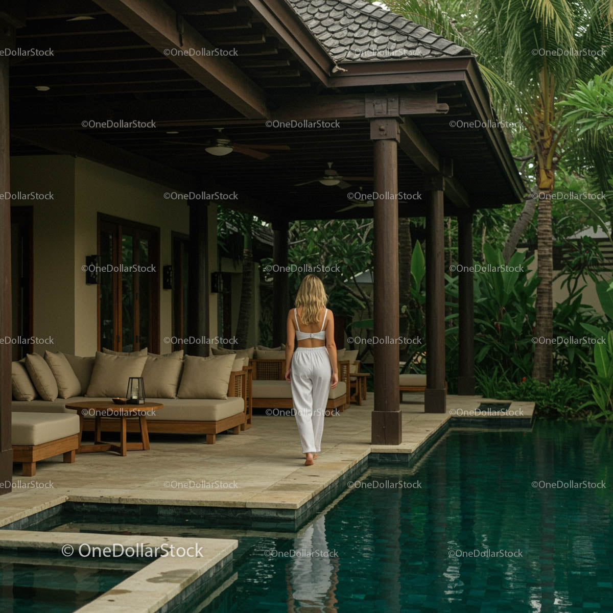 Woman in White Walking by a Luxury Tropical Poolside Villa