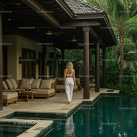 Woman in White Walking by a Luxury Tropical Poolside Villa