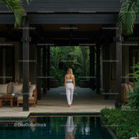 Woman Strolls Through Tropical Villa Garden