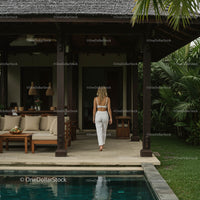 Woman in White Relaxing by Poolside at Tropical Villa