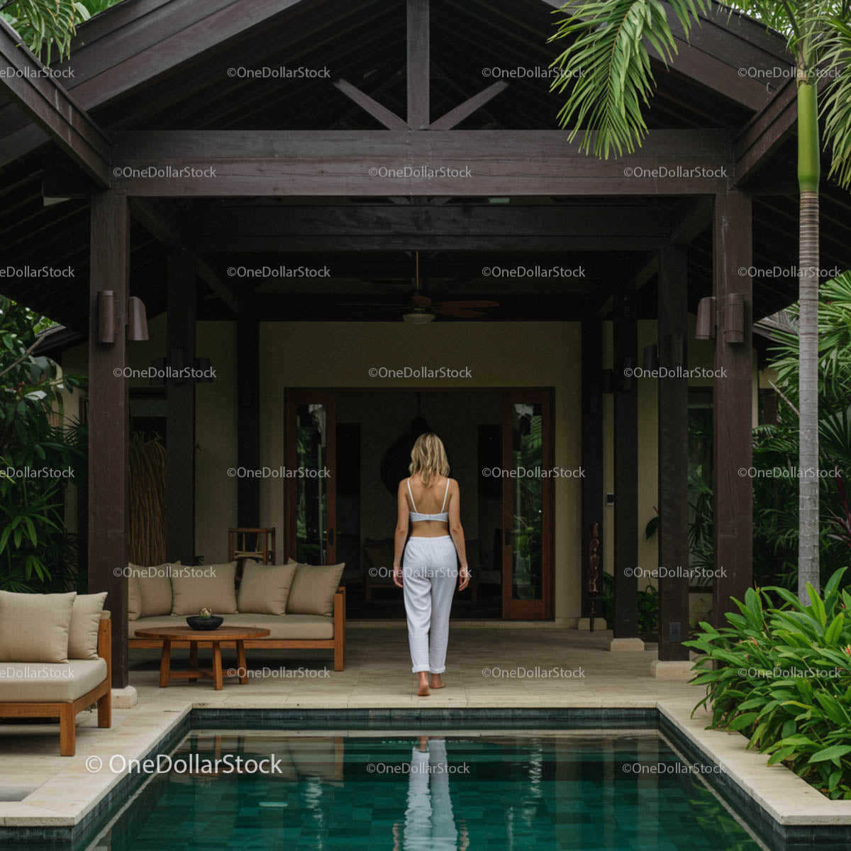Woman Enjoying Luxurious Villa with Pool and Palm Trees