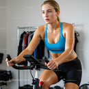 Focused Woman Exercising on Indoor Bike in Home Gym