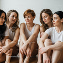 Group of Diverse Women Sitting Together in Casual White T-Shirts