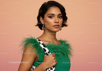 Elegant Woman in Green Dress with Feather Details and Jewelry