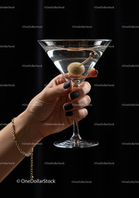 Hand Holding Classic Martini Glass with Olive