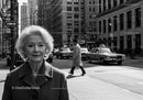 Elderly Woman in Busy City Street Surrounded by Vintage Cars
