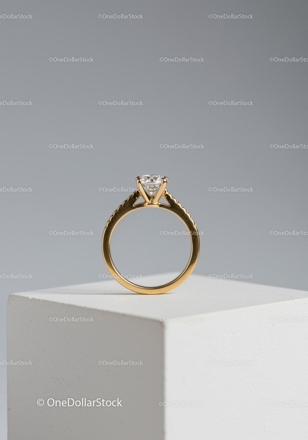 Elegant Gold Ring with Solitaire Diamond on White Pedestal
