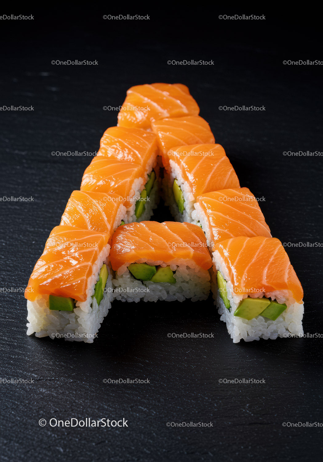 Rolki sushi ułożone w kształt litery A na czarnym łupku