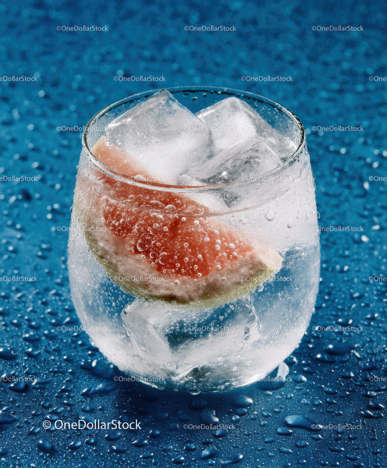 Glassy Cold Drink with Grapefruit Slice and Ice Cubes
